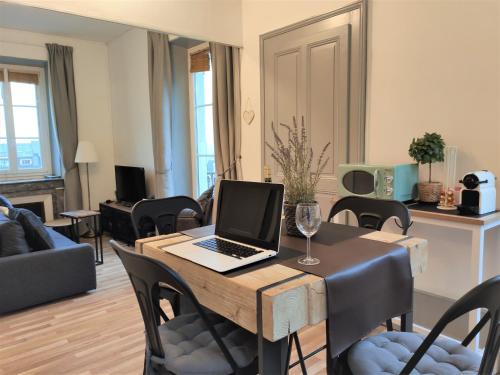 a living room with a table with a laptop on it at Coeur d'Aix, vue splendide et cachet in Aix-les-Bains