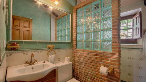 a bathroom with a sink and a brick wall at La Huerta del Tajo - Grande Ronda by Ruralidays in Ronda