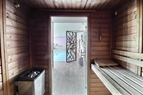 an empty sauna with a glass door and wooden walls at Grand Hôtel des Bains SPA in Fouras