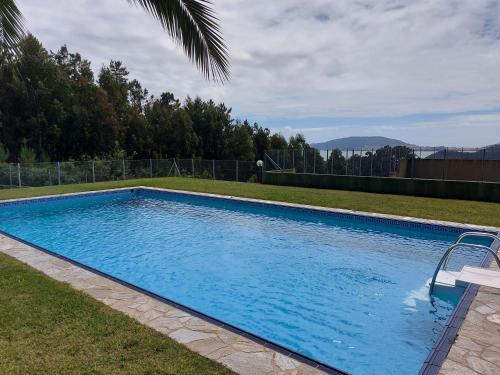 a large blue swimming pool in a yard at APARTAMENTO ESTORDE - COSTA DA MORTE in Cee