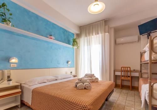 a bedroom with two beds and a blue wall at Hotel City in Misano Adriatico