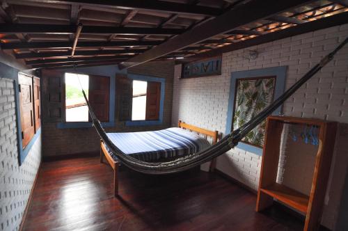 a hammock in the middle of a room at Casa Blanka 2010 - Eco Surf Guest House in Itacaré