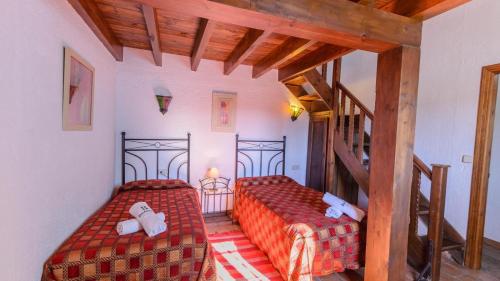 a bedroom with two beds and a staircase at Los Arrieros Júzcar by Ruralidays in Júzcar