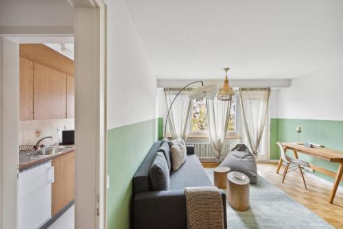 ein Wohnzimmer mit einem Sofa und einem Tisch in der Unterkunft Central Lucerne Apartments in Luzern