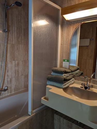 a bathroom with a sink and a shower and a mirror at Hotel De Gravin van Vorden in Vorden