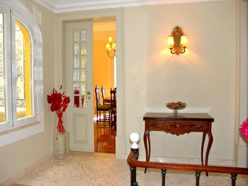 a hallway with a table and a vase of flowers at Casa do Colegio Velho in Vila Viçosa