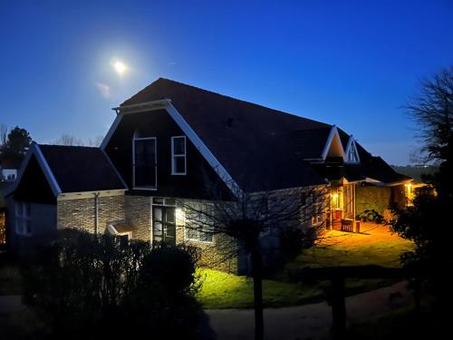 a house at night with the moon in the sky at Bed & Bos de 14 Sterren in Den Burg