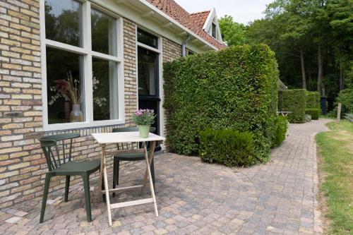 a table and chairs on a brick patio at Bed & Bos de 14 Sterren in Den Burg