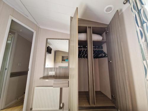 Habitación con espejo y armario. en Beautiful 3-Bed Caravan at Rockley Park Poole, en Poole