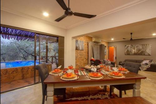 - une salle à manger avec une table et de la nourriture dans l'établissement Kaya KaBush, à Marloth Park