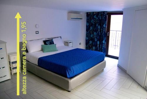 a bedroom with a bed with a blue comforter at Luan House in San Giorgio a Cremano