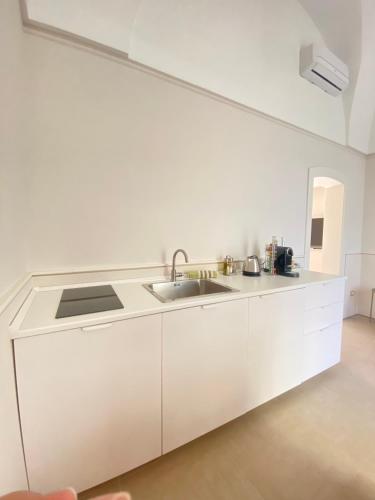 a kitchen with white cabinets and a sink at Bottego24 Suite, Apartment & Terrace in Nardò