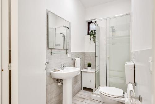 a white bathroom with a toilet and a sink at Catania Modern Beige Apartment in Catania