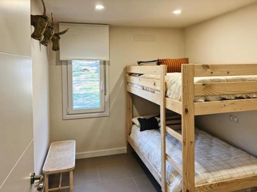 two bunk beds in a room with a window at El Escondite de La Caprichosa in Madrid