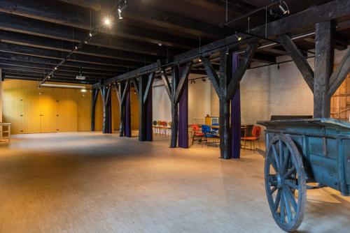 a large room with a wooden floor and wooden beams at Hotel Napoleonschuur in Amerongen