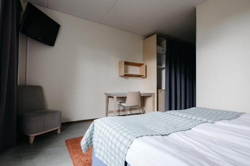 a bedroom with a bed and a desk and a chair at Lapland Hotels Ylläskaltio in Äkäslompolo