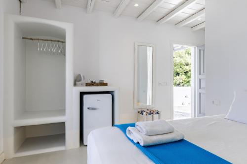 a white bedroom with a bed with towels on it at Evlalia Studios & Villas in Skopelos Town