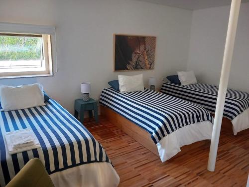 a room with two beds and a window at HI Vila do Conde - Pousada de Juventude in Vila do Conde