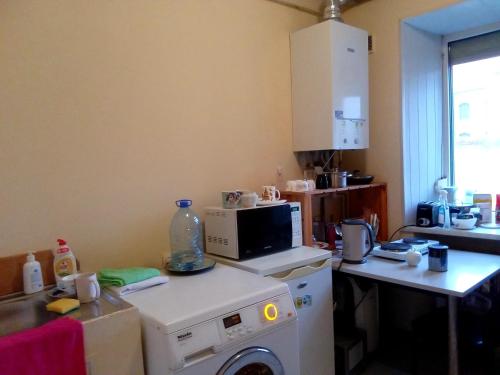 cocina con lavadora y microondas en Vilnius Old Town accommodation, en Vilna
