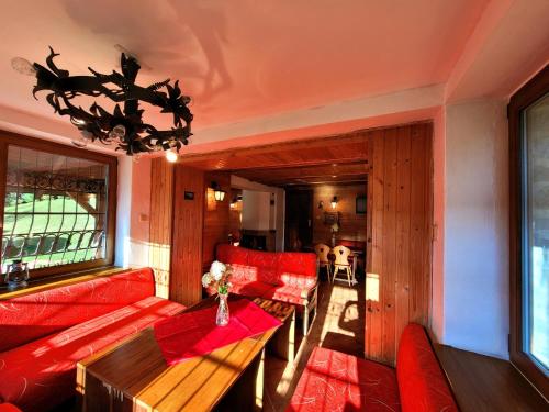 a living room with red couches and a table at Horská chata Kouty in Loučná nad Desnou