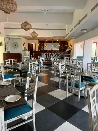 a restaurant with a checkered floor and tables and chairs at Otium Goa Resort by The Oterra in Porvorim