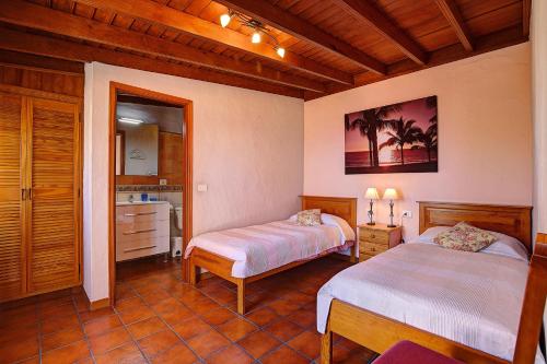 a bedroom with two beds and a bathroom at Finca Marina BuenVivir in Tazacorte