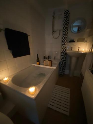 a bathroom with a tub and a sink with lights at Stunning Cottage in Holyhead in Holyhead