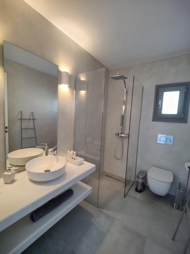 a bathroom with two sinks and a shower and a toilet at Alexander Suites in Drios