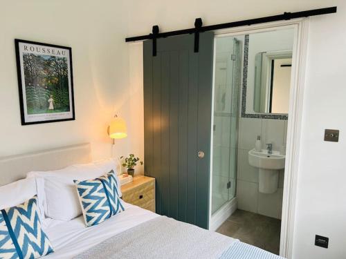 a bedroom with a bed and a shower and a sink at Forge Cottage - Pretty 1 Bedroom Cottage with Free Off Street Parking in London