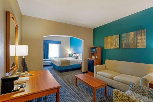 Habitación de hotel con cama y sala de estar. en Best Western Governors Inn and Suites, en Wichita