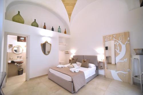 a bedroom with a bed and a mirror and a sink at L'Antica Rimessa Da Gigi in Gallipoli