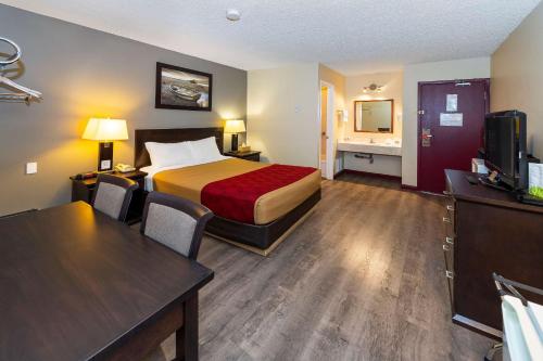 a hotel room with a bed and a desk at Econolodge Edson in Edson