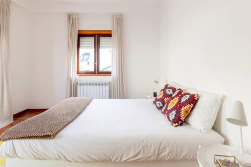 - une chambre dotée d'un lit blanc avec un oreiller dans l'établissement Casa da Avó, à Chaves