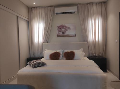 Un dormitorio con una cama blanca con dos ositos de peluche. en Star Hawana Salalah Forest Island en Salalah