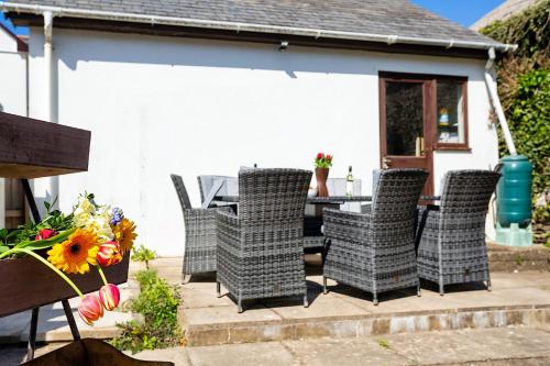a group of chairs and a table on a patio at CROYDE BRIAR HOUSE 4 Bedrooms in Croyde