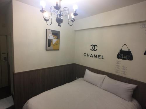 a bedroom with a bed with a chandan sign on the wall at Love Feng Jia Apartment Hotel in Taichung