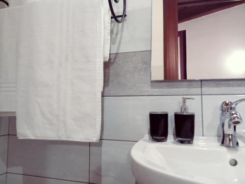 La salle de bains est pourvue d'un lavabo et d'un miroir. dans l'établissement Agriturismo Pedru Caddu, à Tula