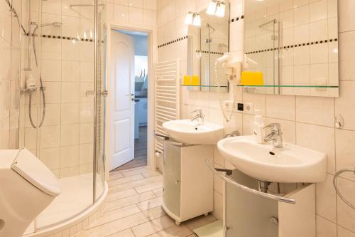 a bathroom with two sinks and a shower at LH Westermüür, App 3 in Braderup