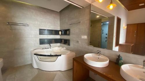 a bathroom with two sinks and a large mirror at Willo Stays On the beach holiday home in Kannur