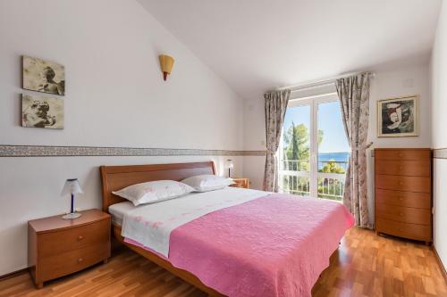 a bedroom with a large bed and a window at Apartments Croatia in Trogir