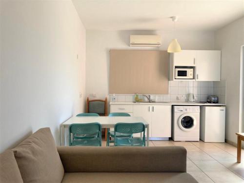 sala de estar con mesa y sillas en la cocina en Ariadne Apartments en Pafos