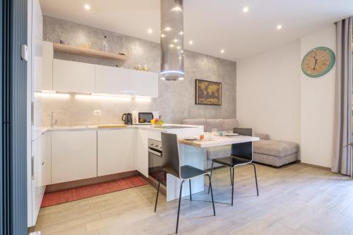 a kitchen with white cabinets and a table and chairs at Residence Cairoli 9 by Studio Vita in Bologna