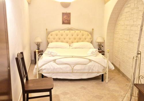 グロッターリエにあるSuite San Francescoのベッドルーム(白いベッド1台、椅子、テーブル付)