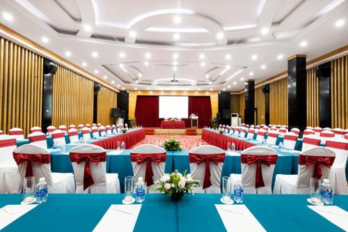 a conference room with blue tables and red chairs at Bao Son International Hotel in Hanoi