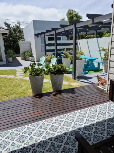 a wooden deck with two potted plants on it at South Point Guest Lodge in Agulhas