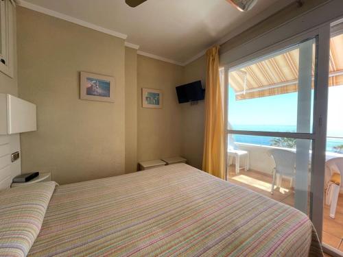 - une chambre avec un lit et une grande fenêtre dans l'établissement Apartamento Calma Chica, à Torremolinos