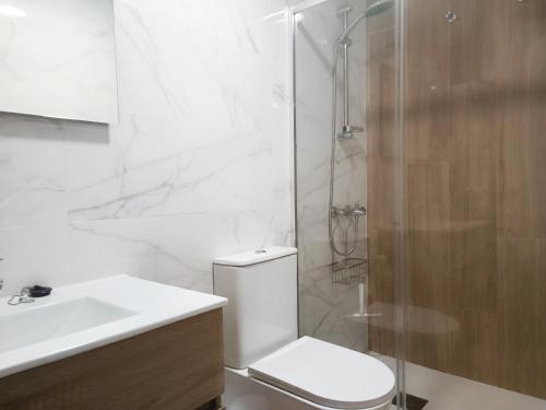ein Bad mit einer Dusche, einem WC und einem Waschbecken in der Unterkunft NUE - Nuevo, 2 dormitorios, Wifi, Smart TV, Playa in Fuengirola