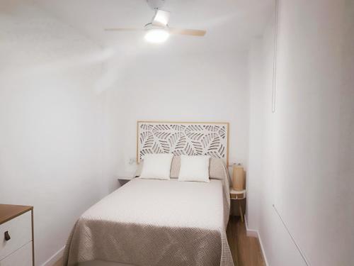 ein kleines Schlafzimmer mit einem Bett und einem Deckenventilator in der Unterkunft NUE - Nuevo, 2 dormitorios, Wifi, Smart TV, Playa in Fuengirola