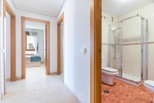 La salle de bains est pourvue de toilettes et d'une douche en verre. dans l'établissement Piso 3 habitaciones plaza de garaje privada y gratuita, à Almería