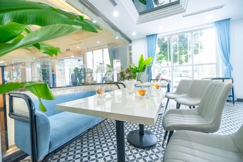 a dining room with a white table and chairs at Bao Son International Hotel in Hanoi